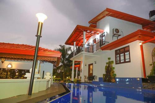 ein Haus mit einem Swimmingpool vor dem Haus in der Unterkunft Peacock Hill Villa in Matugama