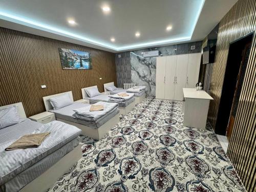 une chambre d'hôtel avec deux lits et un canapé dans l'établissement Amiriy hostel, à Boukhara