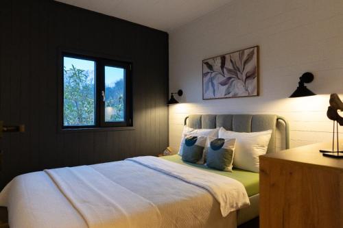 una camera da letto con un letto con lenzuola bianche e una finestra di Cabana pe Deal a Remetea Chioarului