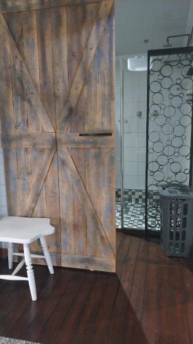 eine hölzerne Schiebetür mit einer weißen Bank davor in der Unterkunft Log in At 118 Loghome in Meyerton