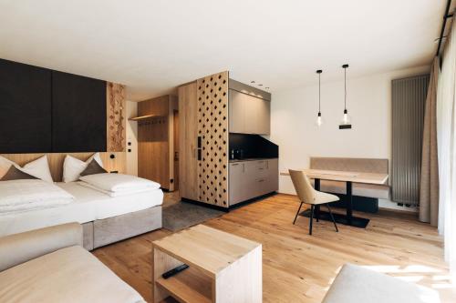 a bedroom with a bed and a desk in a room at Hotel Ansitz Gamp in Chiusa