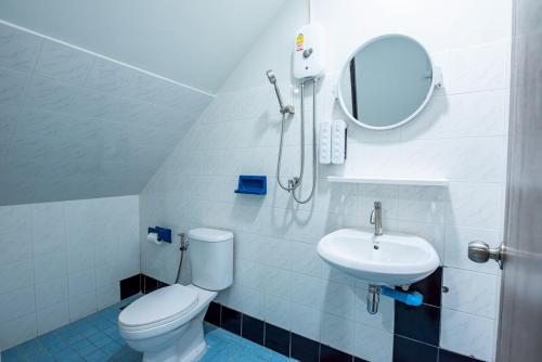 um banheiro com um vaso sanitário, uma pia e um espelho em Coral Beach House Rayong em Ban Noen Phra