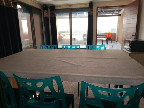 Spacious 2-Bedroom Apartment with Terrace & Multiple Bathrooms في Dargai: طاولة وكراسي في غرفة بها نوافذ