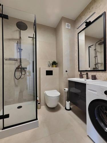 a bathroom with a shower and a toilet and a sink at Rewal Komfortowy Apartament 2 Sypialnie 10 min od Plaży Parking Taras Grill in Rewal