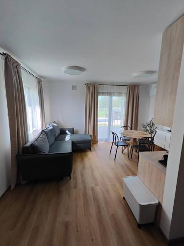 a living room with a couch and a table at Rewal Komfortowy Apartament 2 Sypialnie 10 min od Plaży Parking Taras Grill in Rewal