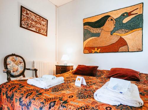 a bedroom with a bed with towels and a painting on the wall at Casa da Rampa By Gt House in Sintra