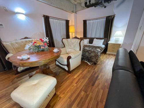 a living room with a table and a couch at Guest House Koza Gate2 in Okinawa City
