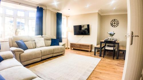 a living room with a couch and a table at Stunning 5 Bedroom House in London - Sleeps up to 10 guests - Business - Contractors - Families - Leisure - WiFi - Parking - Garden in Grove Park