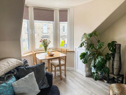 a living room with a table and a plant at The Wee Pad - Uk42918 in Dunfermline