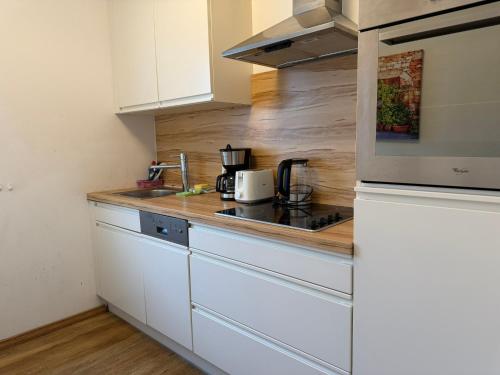 a kitchen with white cabinets and a counter top at Kaprun 1 in Kaprun