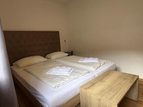 a bedroom with two beds and a wooden table at Kaprun 1 in Kaprun