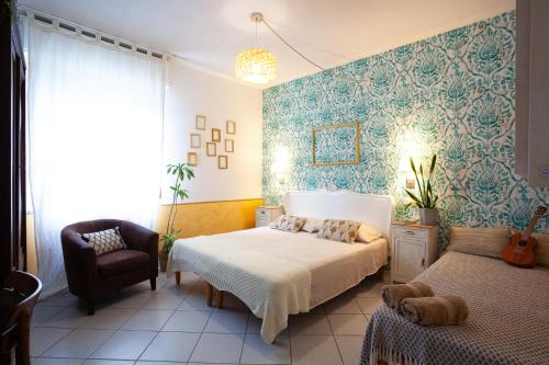 a bedroom with a bed and a chair at B&B La Volpina in Rimini