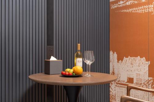 uma mesa com uma garrafa de vinho e um copo em UrCove by Hyatt Xi'an Bell Tower Huimin Street Hotel em Xian