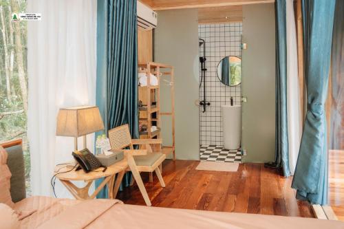 une chambre avec un lit et une chaise et une douche dans l'établissement Rung Thong Nui Voi Villa & Resort, à Ðưc Trọng