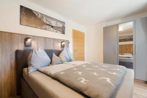 een slaapkamer met een groot bed met een houten hoofdeinde bij Apart Dahoam in Wiesing