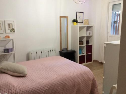 a bedroom with a bed with a pink blanket at Apartamento Vergeles-Congresos in Granada