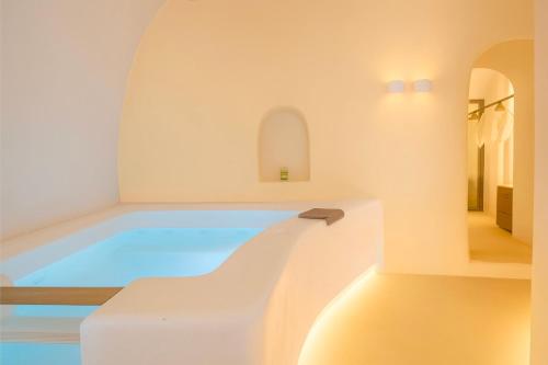 a pool in a white room with an archway at Chic Hotel Santorini in Firostefani