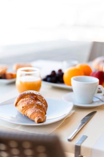 einen Frühstückstisch mit einem Teller mit Essen und Obst in der Unterkunft Cilento Dreams Village in Marina di Camerota