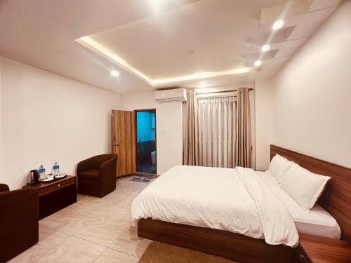 Un dormitorio con una cama y una silla dentro. en Little Buddha Inn, en Katmandú