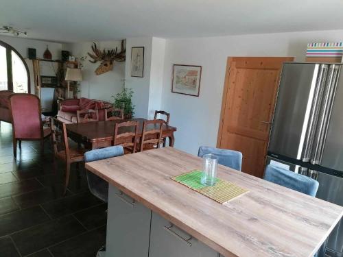 Il comprend une cuisine et une salle à manger avec une table et un réfrigérateur. dans l'établissement Le 115 Retour aux Sources, à Dounoux