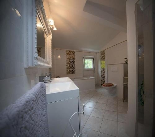 une salle de bains avec lavabo, baignoire et toilettes dans l'établissement Maison confortable et calme, à Lens