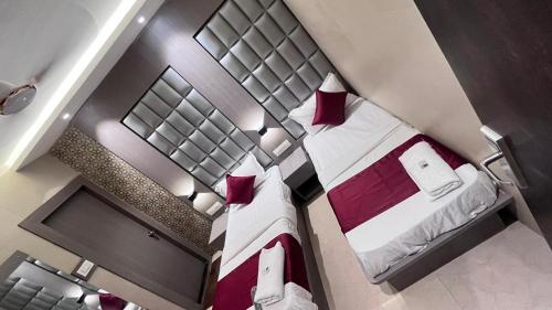 孟买Hotel Abrol Suites的一间带两张床和红色枕头的酒店房间