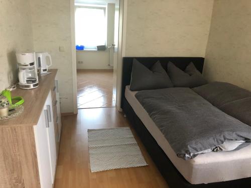 a large bed in a small room with a kitchen at Pension Ute in Strehla