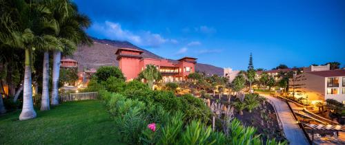 ein großes rotes Gebäude mit Palmen in einem Park in der Unterkunft La Palma Princess in Fuencaliente de la Palma