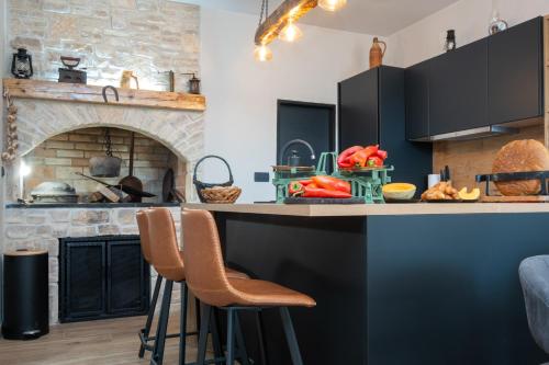 eine Küche mit einer Theke mit Stühlen und einem Kamin in der Unterkunft Winter holidays in Holiday home Olive garden Platinum in Posedarje