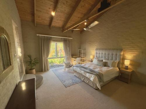 une chambre avec un lit et un bureau dans une pièce dans l'établissement Hartland Garden Suite, à Oudtshoorn