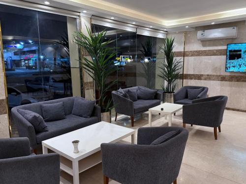 - une salle d'attente avec des canapés, des chaises et des tables dans l'établissement شقق نورسين ان للشقق المخدومة, à Quai