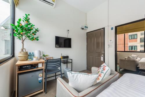 a room with a bed and a desk with a chair at Lachata - Hua Mak in Bangkok