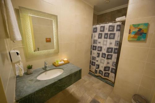 Un baño con lavabo y ducha con espejo. en Corner View Hotel, en Wadi Musa