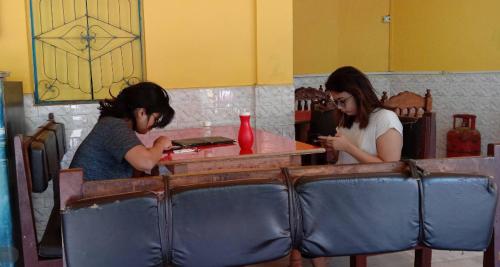 Deux filles assises à une table dans un restaurant dans l'établissement Kempty Lake Waterfall Resort - Run by Anaysha Group, à Mussoorie