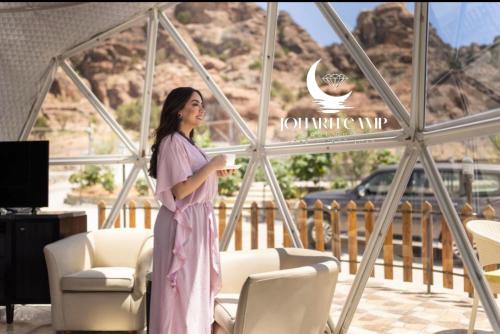 Eine Frau in einem rosa Kleid steht in einem Zimmer in der Unterkunft BUBBlES JOHRH LUXURY CAMP in Disah