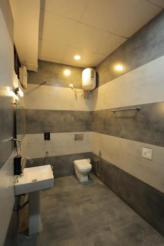 a bathroom with a toilet and a sink at Hotel Kuber in Rāi