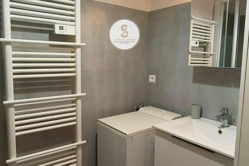 Un pequeño baño con lavabo y lavadora. en Camargue Saintes Maries de la Mer, en Saintes-Maries-de-la-Mer