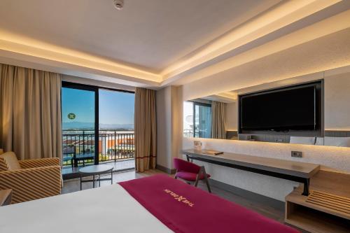 a hotel room with a bed and a flat screen tv at The X Belek in Belek