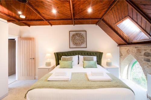 a bedroom with a large bed with wooden ceilings at Northern Hideaways The Old Chapel, Otterburn in Otterburn