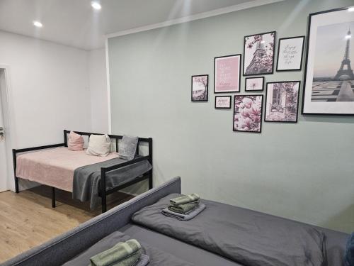 - une chambre avec 2 lits et des photos sur le mur dans l'établissement Stilvolle Wohnung mit Blick und Selbst-Check-in, à Bad Berleburg