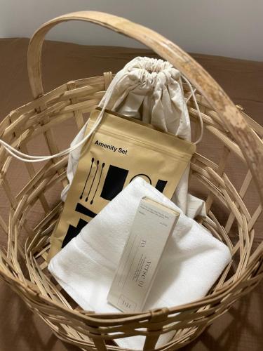 a basket filled with white towels and a receipt at stay early mansion 가산, 홍대, 고척돔 in Seoul