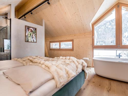 Un dormitorio con una cama grande y una bañera. en Alpegg Chalets, en Waidring