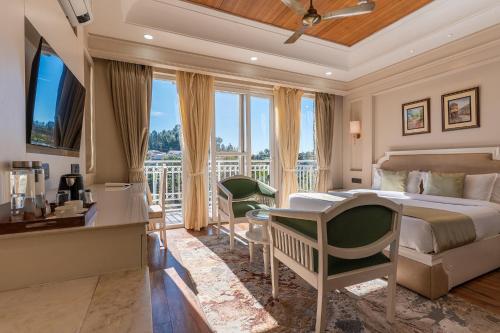 Un dormitorio con una cama y un escritorio y un balcón. en Casa De Bello, Nainital, Near Kainchi Dham, en Bhowāli