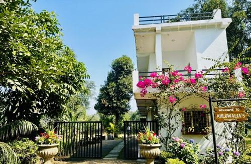 ein Gebäude mit Blumen davor in der Unterkunft Ahluwalias Farmstay in Mandlā