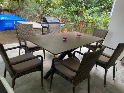 - une table et des chaises en bois sur une terrasse avec barbecue dans l'établissement Welcome to our vacation home in Sutomore, à Sutomore