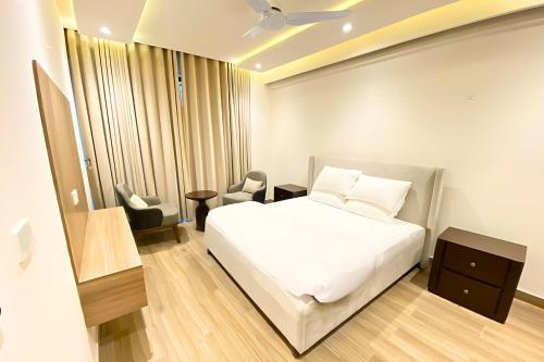 穆里Luxury 2 Bed Apartment in Monal Murree的卧室里有一张白色的床和一把椅子