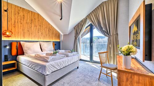 a bedroom with a bed and a desk and a window at Mountain Horizon Valley z basenami, saunami i strefą fitness by Royal Aparts in Szklarska Poręba