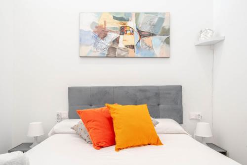 een slaapkamer met een bed met oranje en gele kussens bij VLC Suite Yako in Valencia