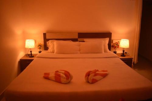 a bedroom with a bed with two towels on it at Kohuwa Resort in Jyoti Gaon