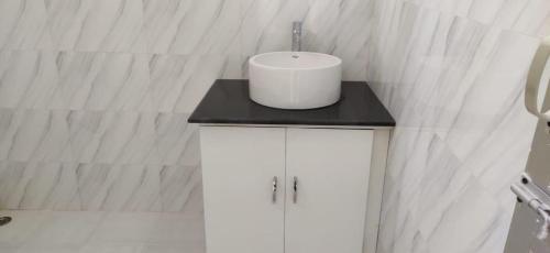 a white bathroom with a sink on a black counter at Kohuwa Resort in Jyoti Gaon